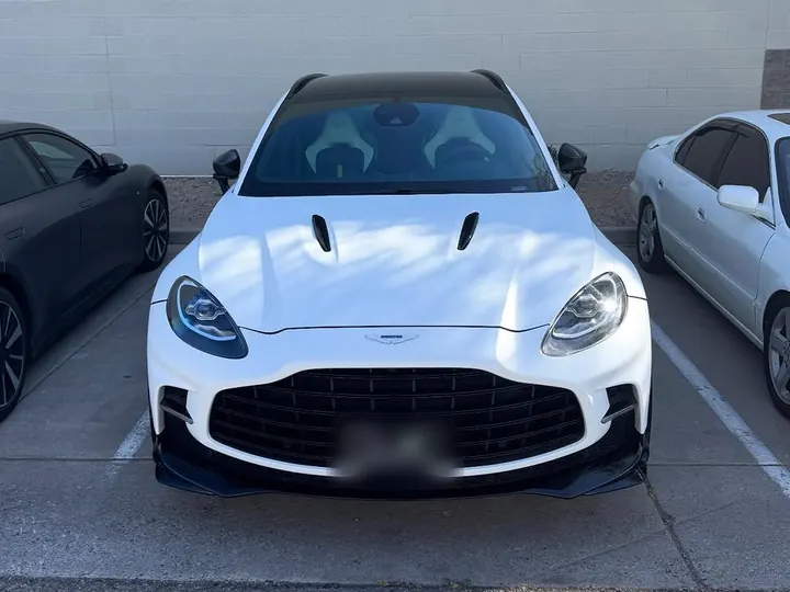 White Aston Martin DBX707 seen head-on in a parking lot
