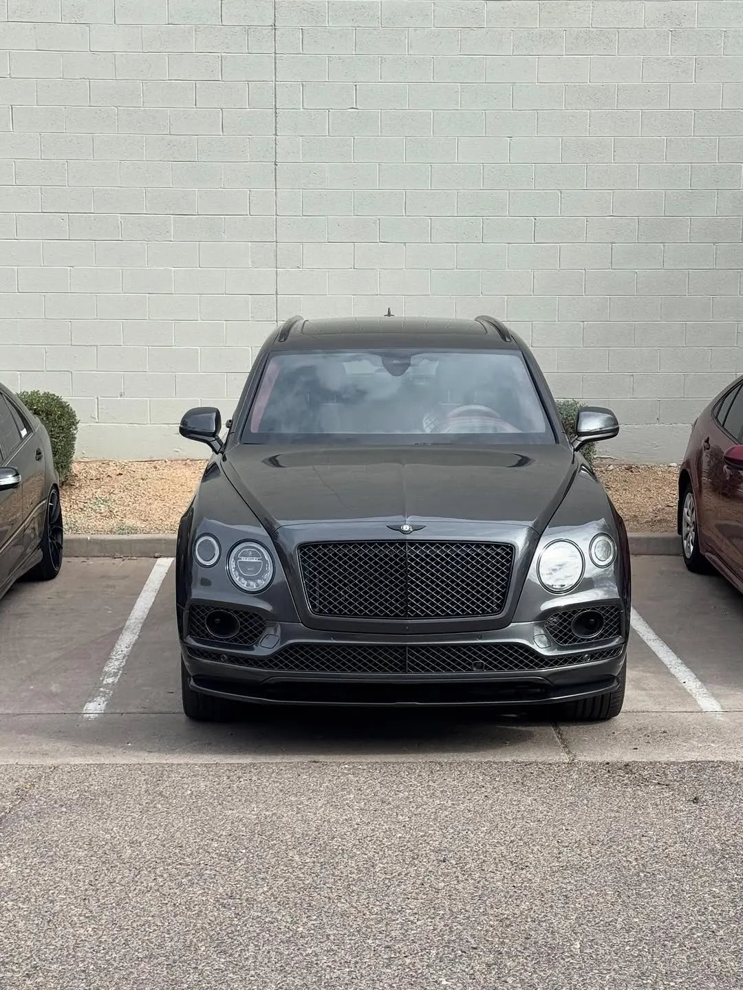 Dark grey Bentley Bentayga seen head-on in a parking space