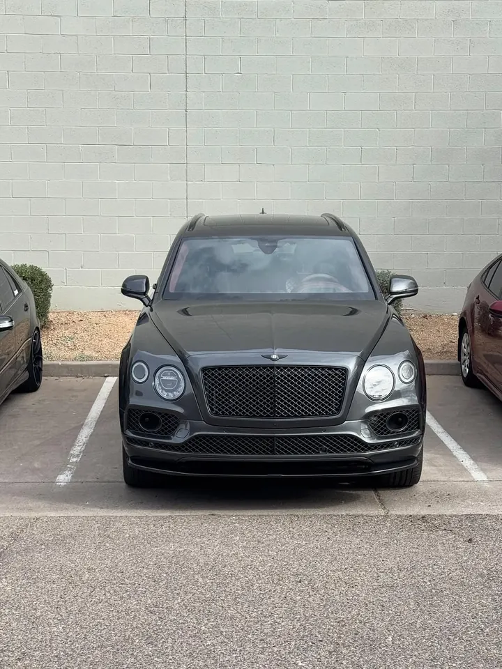 Dark grey Bentley Bentayga seen head-on in a parking space