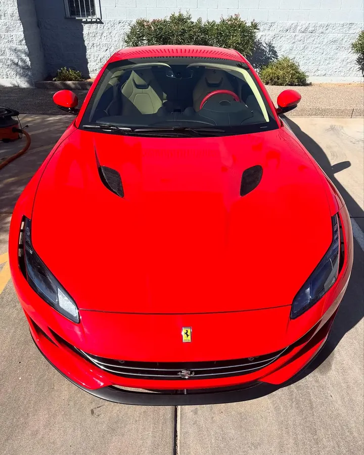 Red Ferrari Portofino seen head-on from above, parked outside the shop