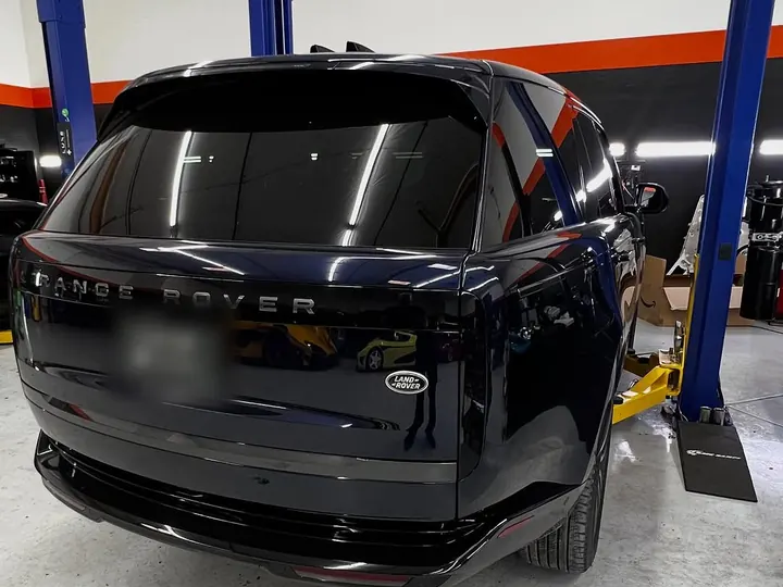 Black Range Rover (L460) seen from behind on a lift in the shop