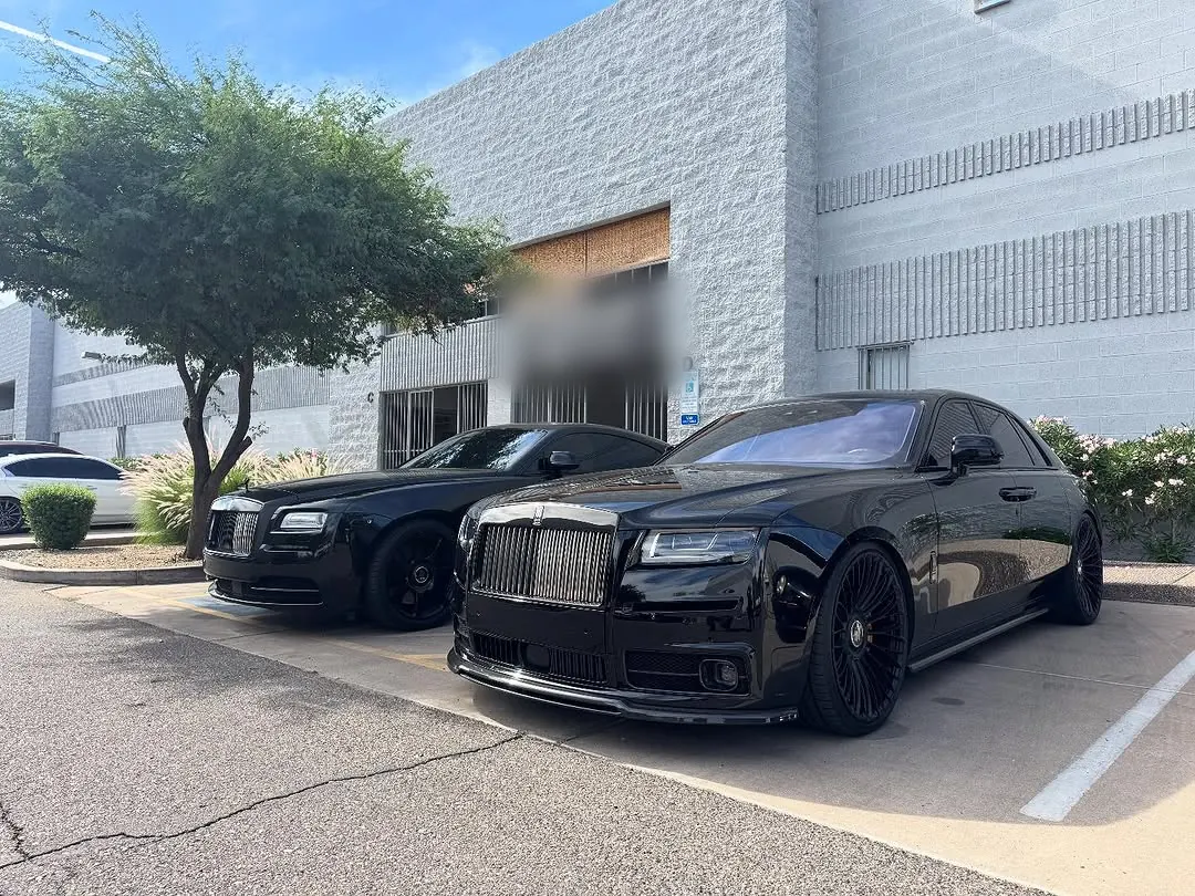 Black Rolls-Royce Wraith and Ghost parked side by side outside the shop