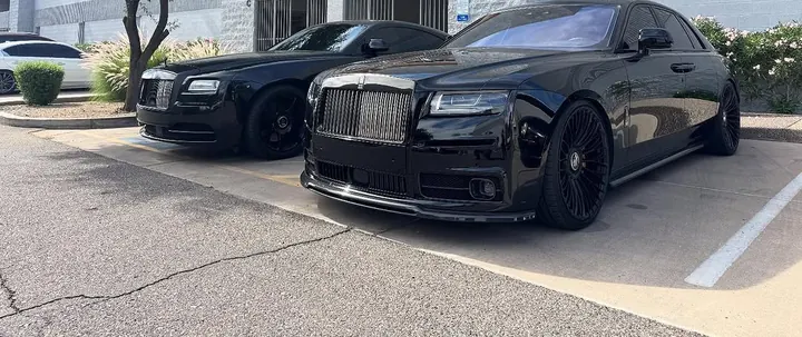 Black Rolls-Royce Wraith and Ghost parked side by side outside the shop