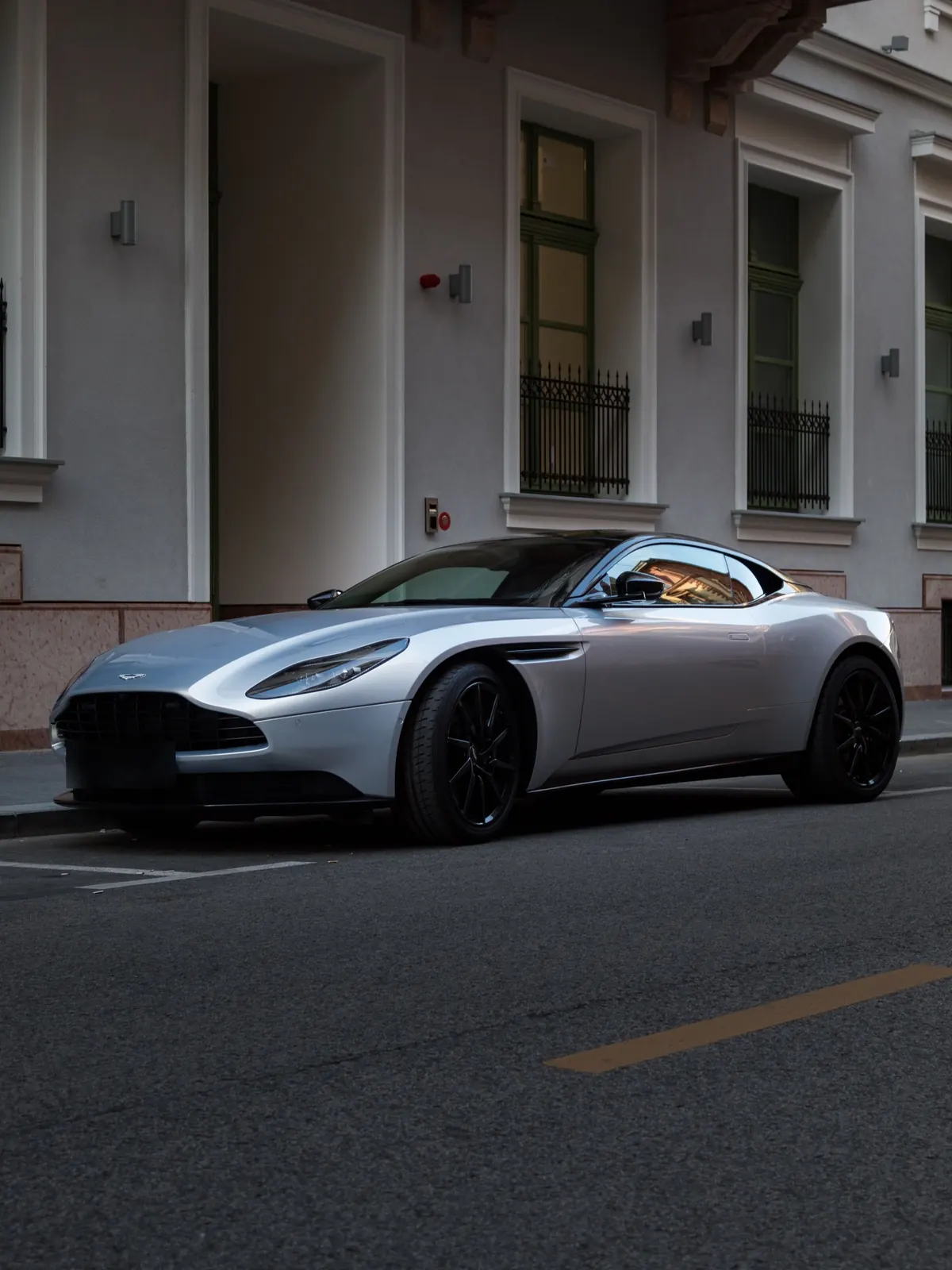 Front three-quarter view of a silver Aston Martin DB11 V8 parked on a city street