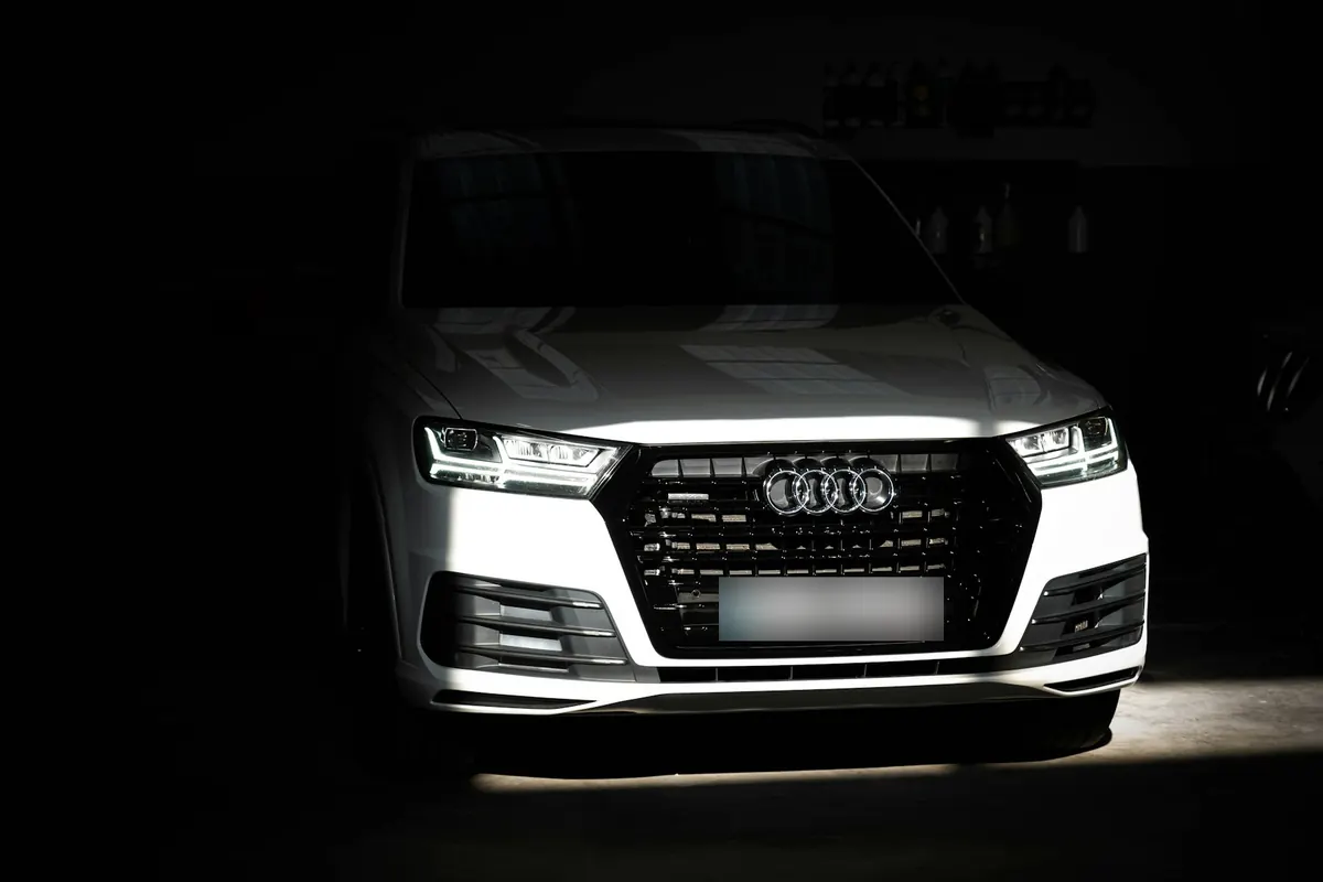 Front view of a white Audi Q7 (4M) in a dark garage
