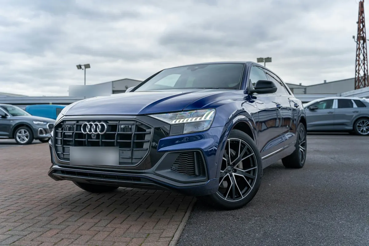 Front three-quarter view of a dark blue Audi Q8 parked on a dealership lot