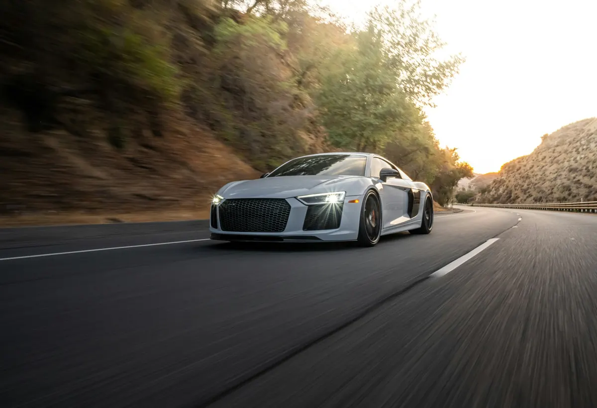 Front three-quarter view of a grey Audi R8 V10 (second generation) driving on a canyon road