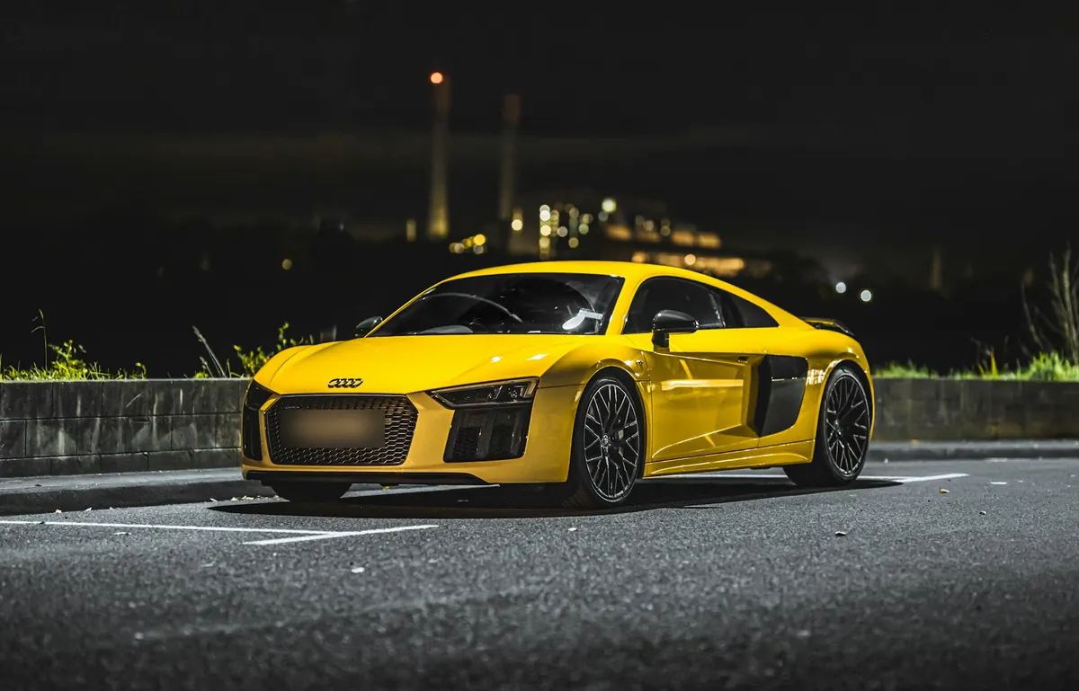 Front three-quarter view of a yellow Audi R8 V10 plus (second generation) parked at night