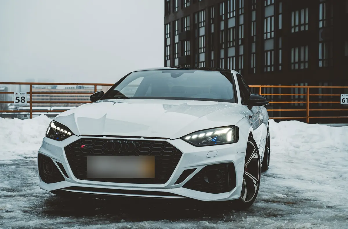 Front view of a white Audi RS 5 (B9) parked on a snowy rooftop