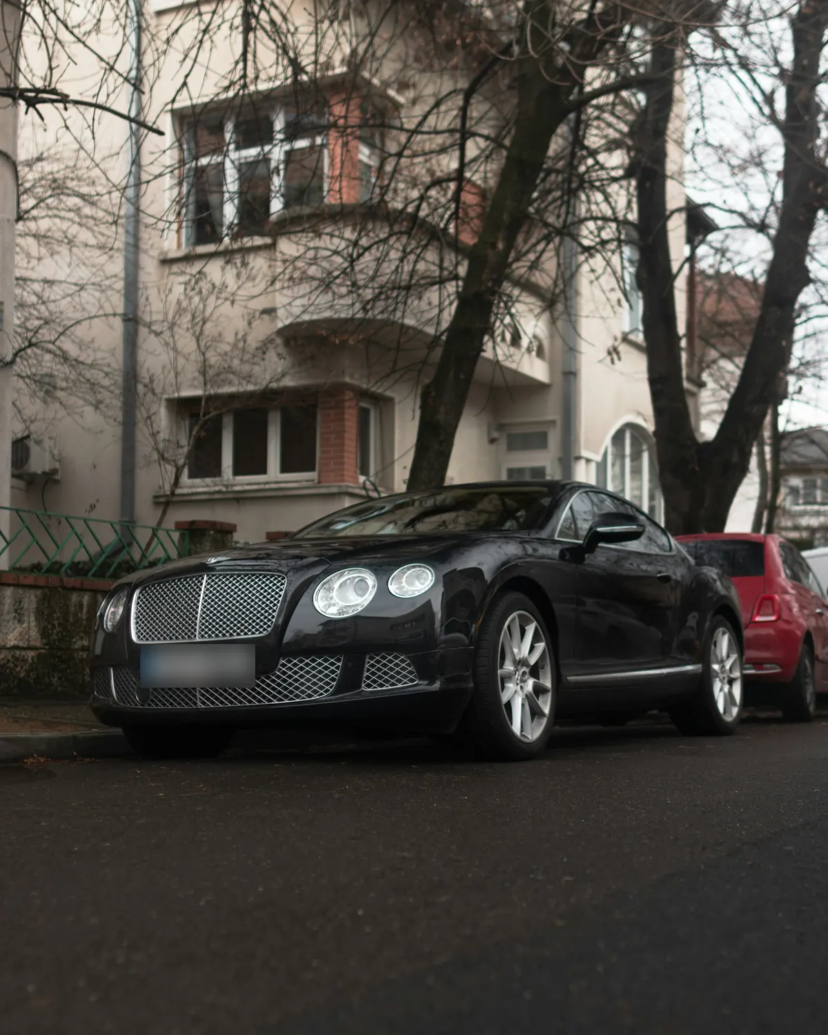 Front three-quarter view of a black Bentley Continental GT W12 (second generation) parked on a residential street