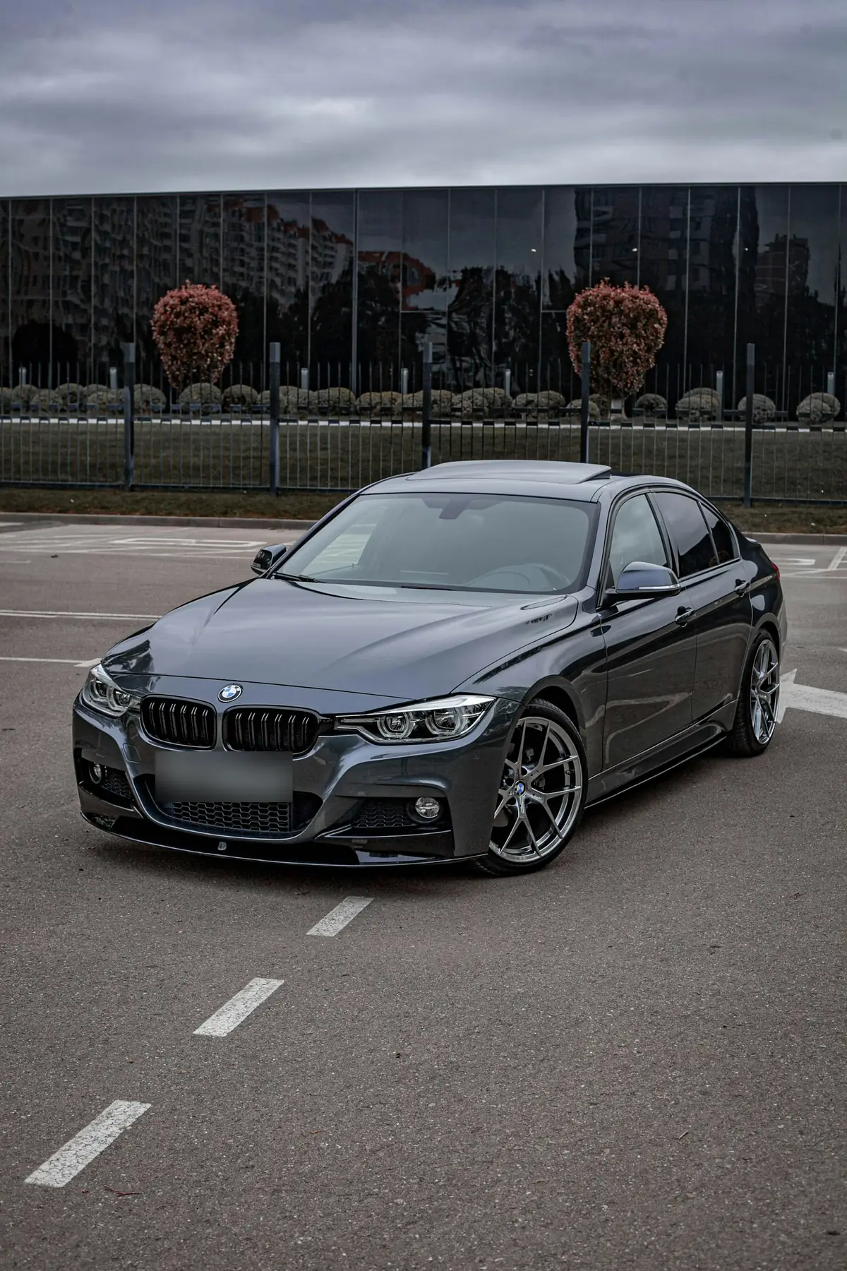 Front three-quarter view of a dark grey BMW 340i (F30) sedan in a parking lot