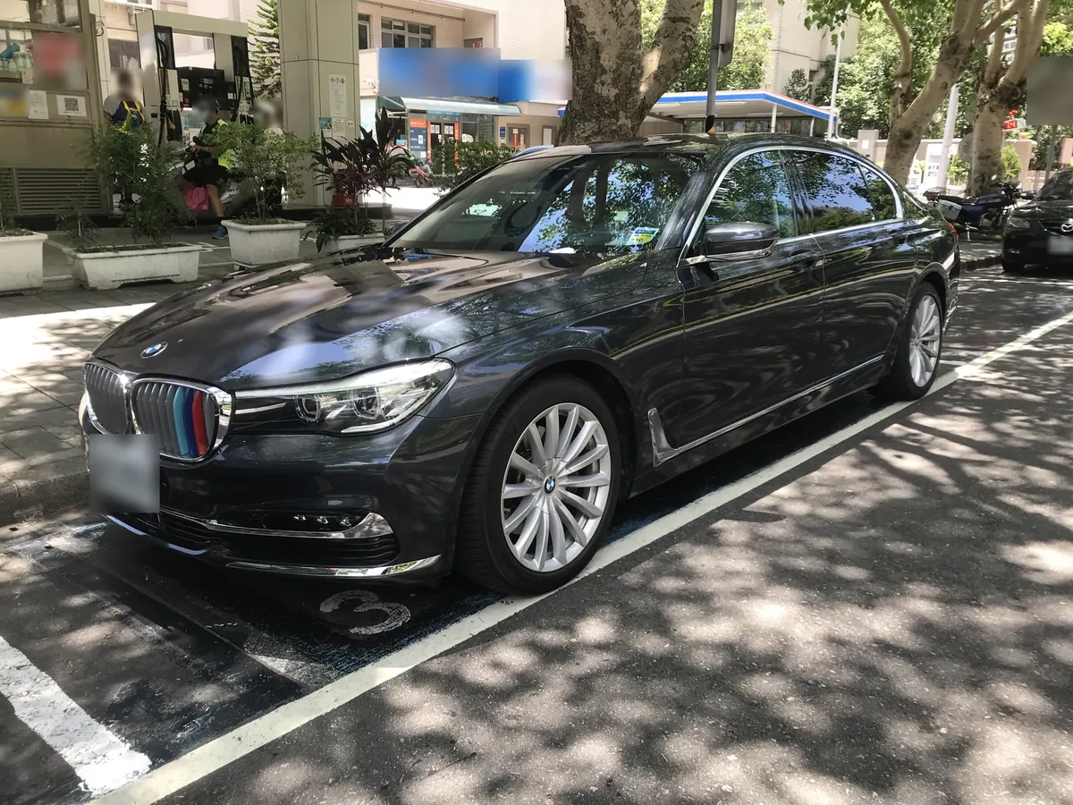 Front three-quarter view of a dark grey BMW M760i xDrive (G12) sedan parked on a street
