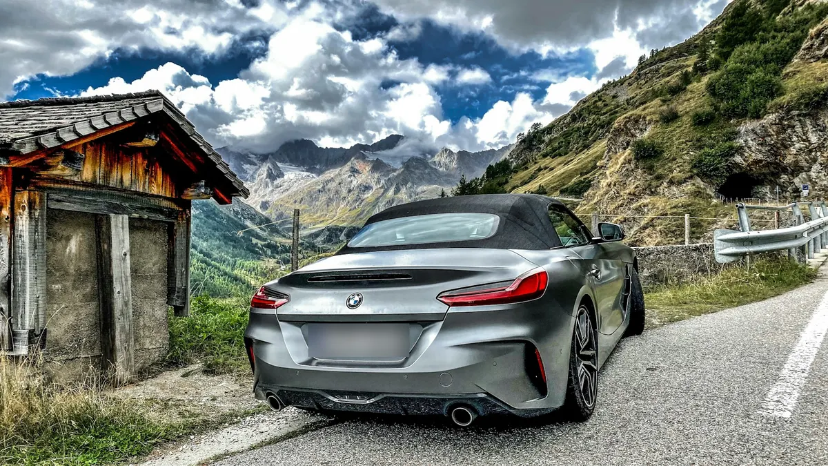 Rear three-quarter view of a grey BMW Z4 M40i (G29) with its roof up on a mountain road