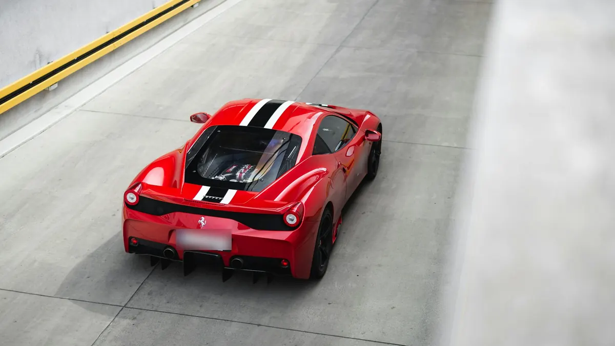 High rear three-quarter view of a red Ferrari 458 Speciale with white and black stripes