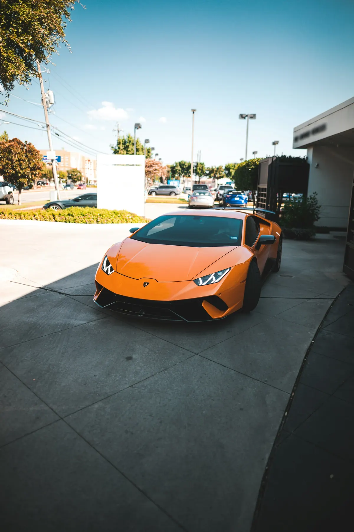 Front three-quarter view of an orange Lamborghini Huracán Performante parked outside a dealership