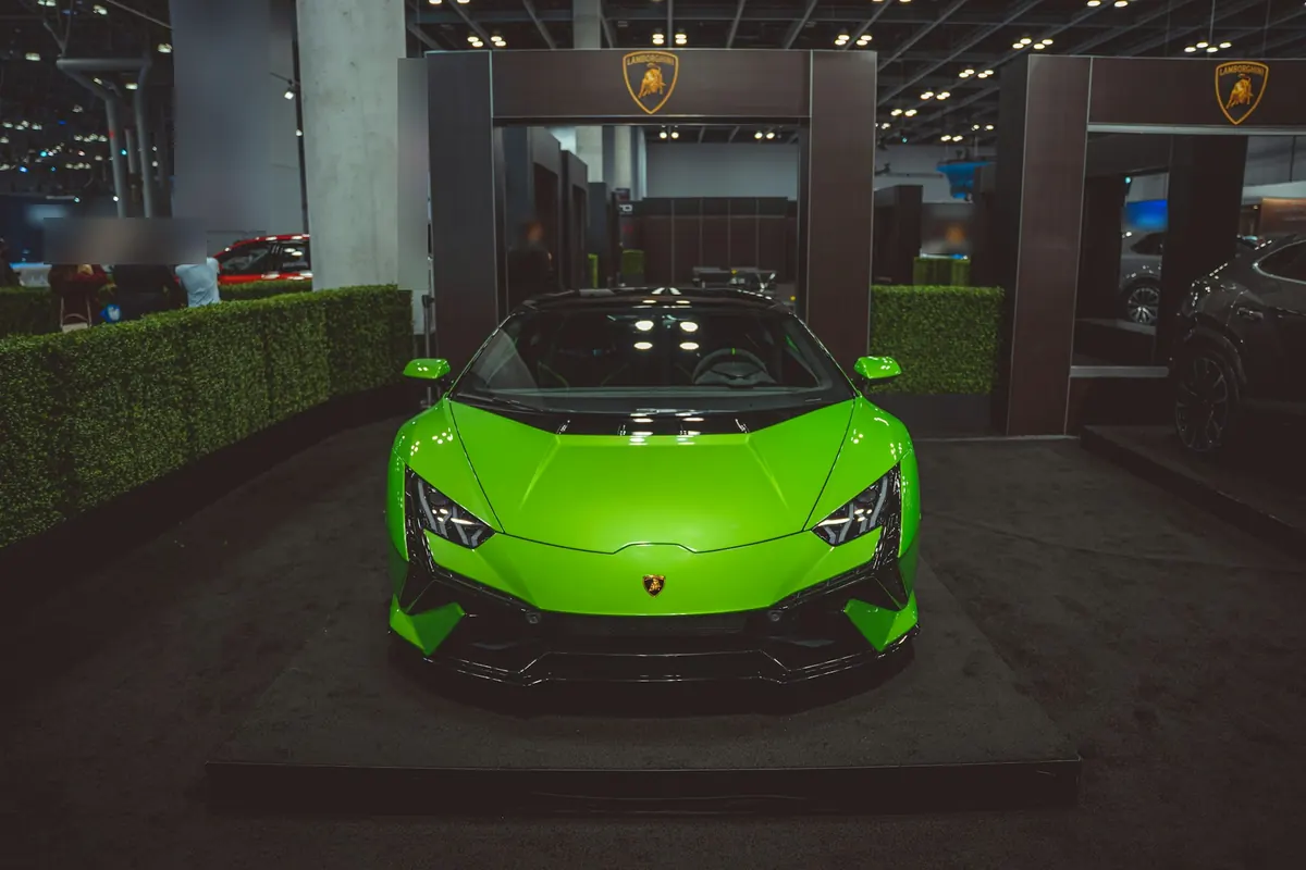 Front view of a green Lamborghini Huracán Tecnica on a show stand