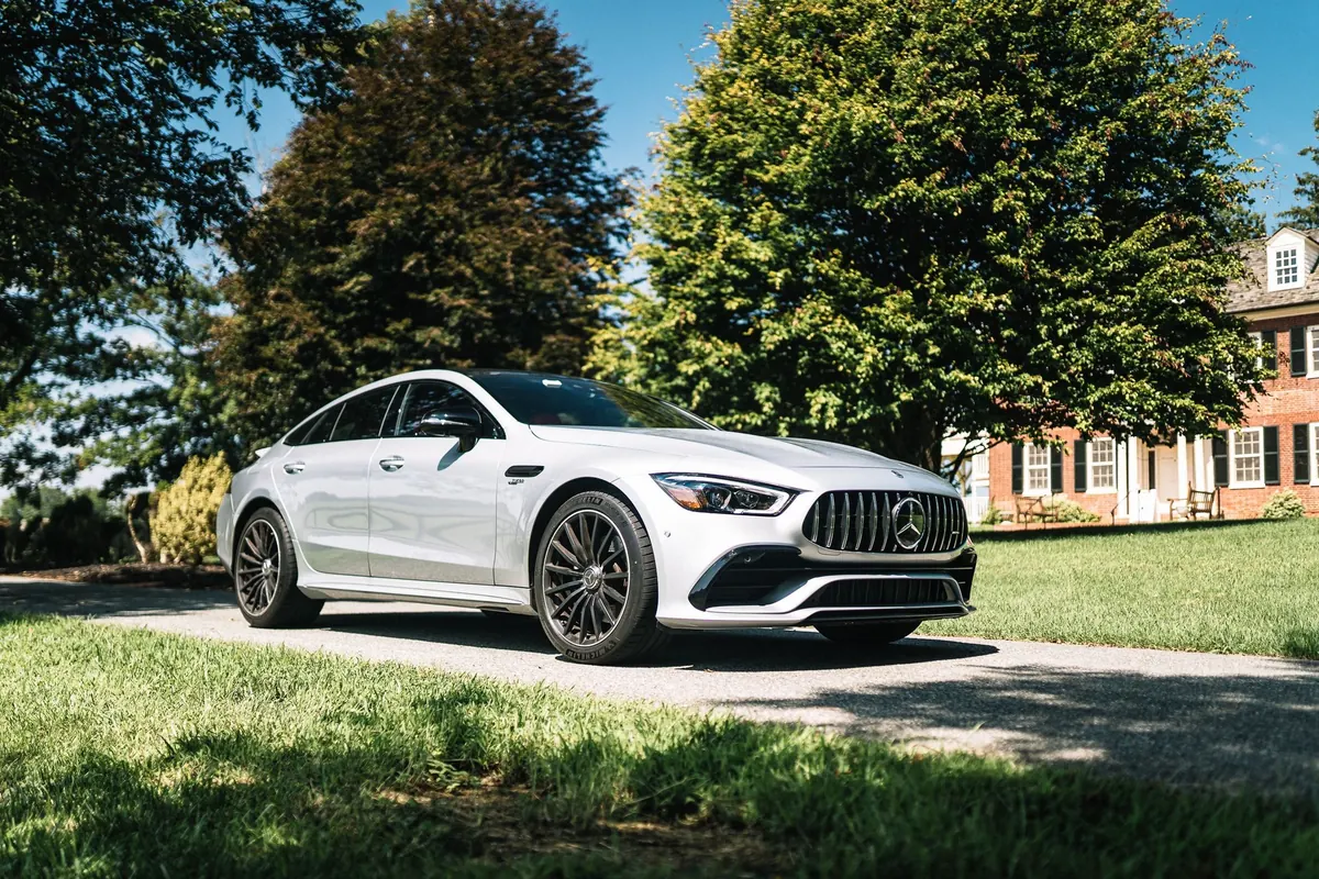 Front three-quarter view of a silver Mercedes-AMG GT 43 4-Door Coupé (X290) on a driveway