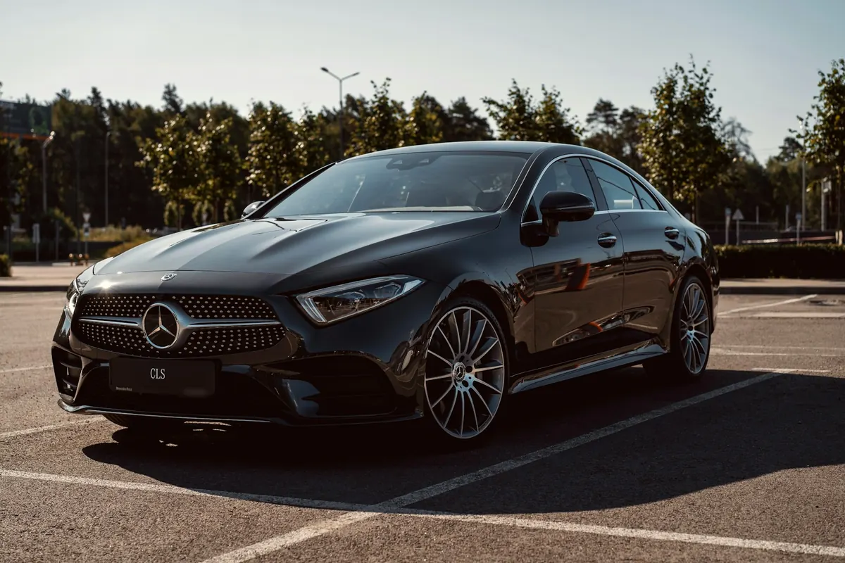 Front three-quarter view of a black Mercedes-Benz CLS450 (C257) in a sunny parking lot