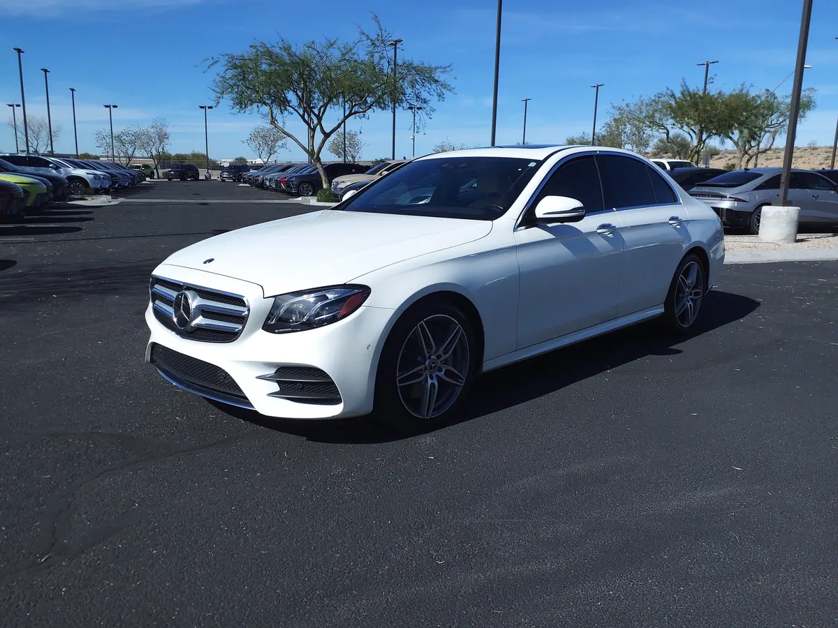 Front three-quarter view of a white Mercedes-AMG E43 (W213) sedan in a parking lot