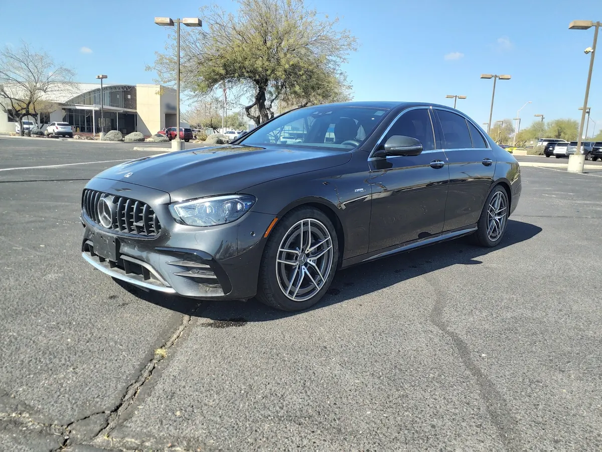 Front three-quarter view of a dark grey Mercedes-AMG E53 (W213) sedan in a parking lot