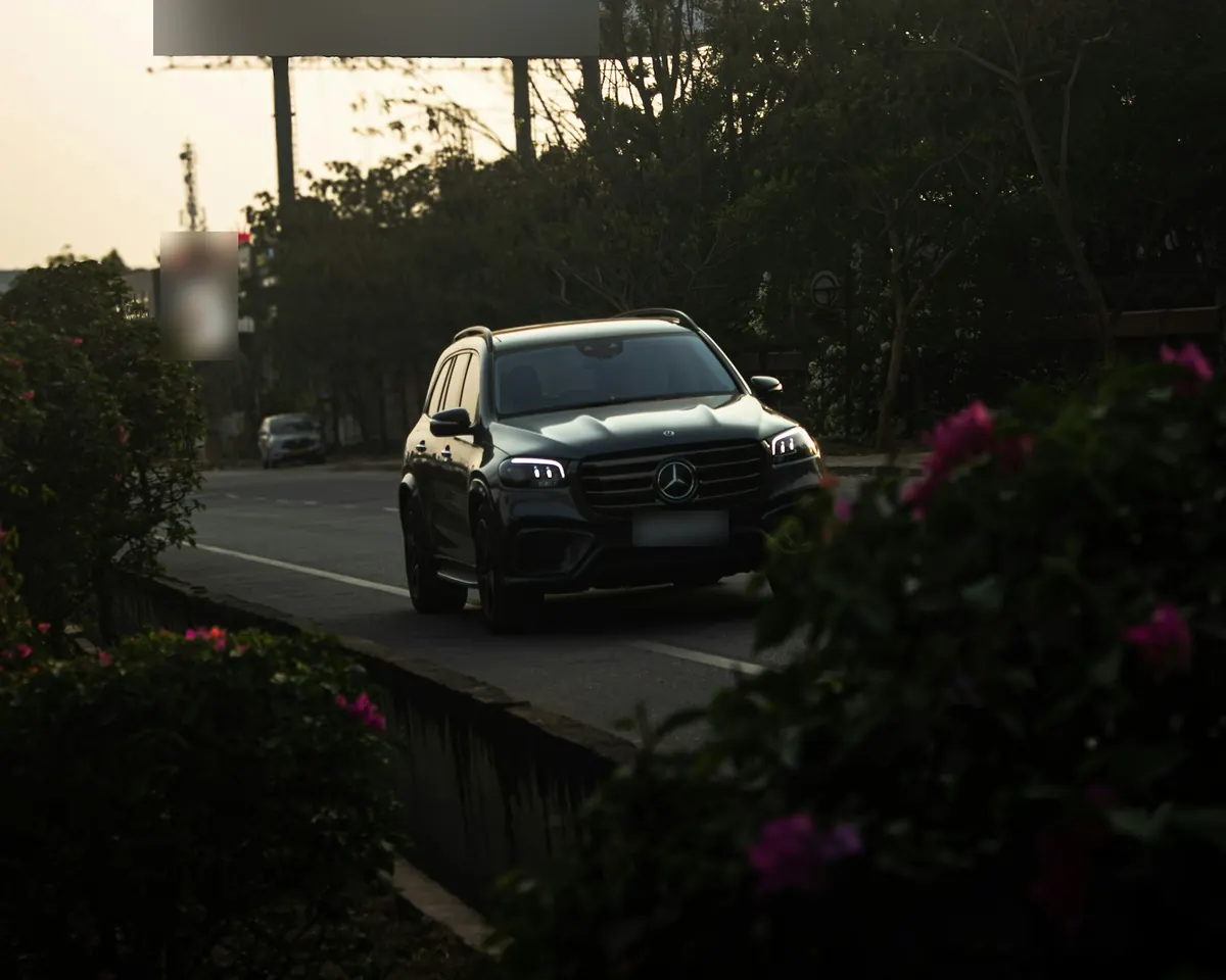 Front three-quarter view of a black Mercedes-Benz GLS450 (X167) on a city road at sunset