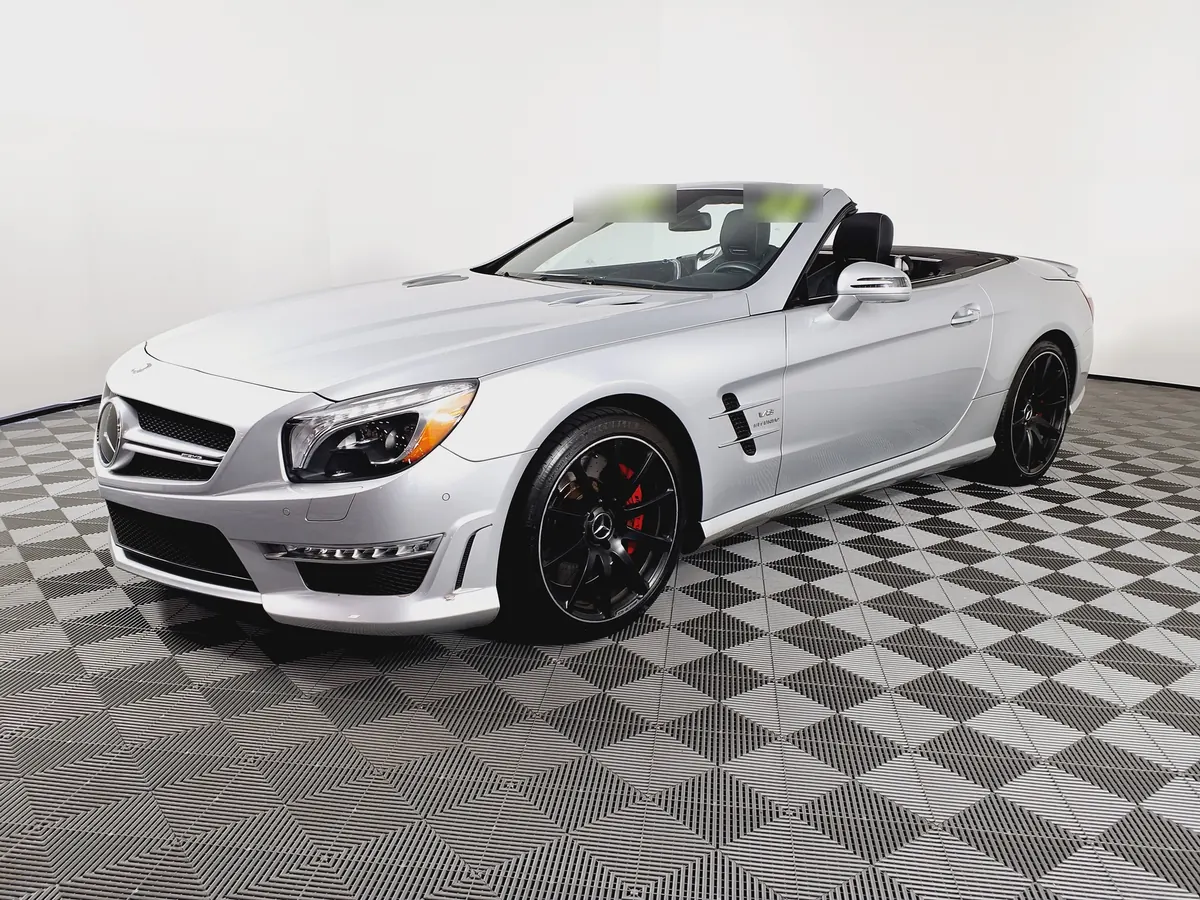 Front three-quarter view of a silver Mercedes-AMG SL65 (R231) with the roof down in a photo studio