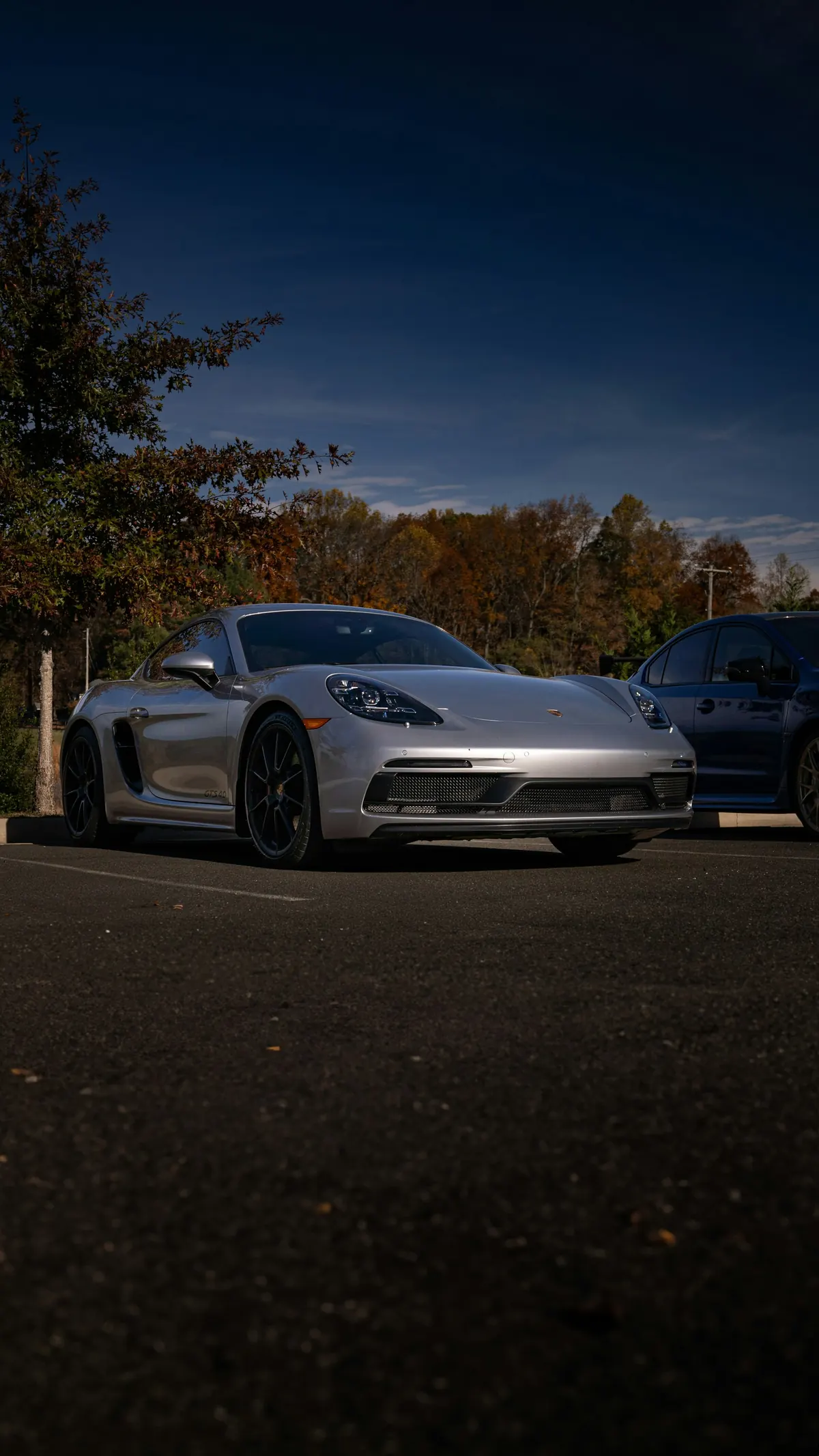 Front three-quarter view of a silver Porsche 718 Cayman GTS (2.5) in a parking lot