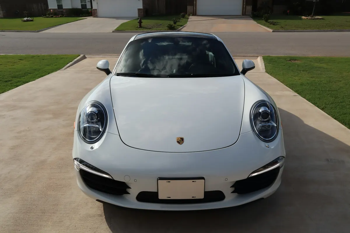 Front view of a white Porsche 911 Carrera (991.1) on a driveway