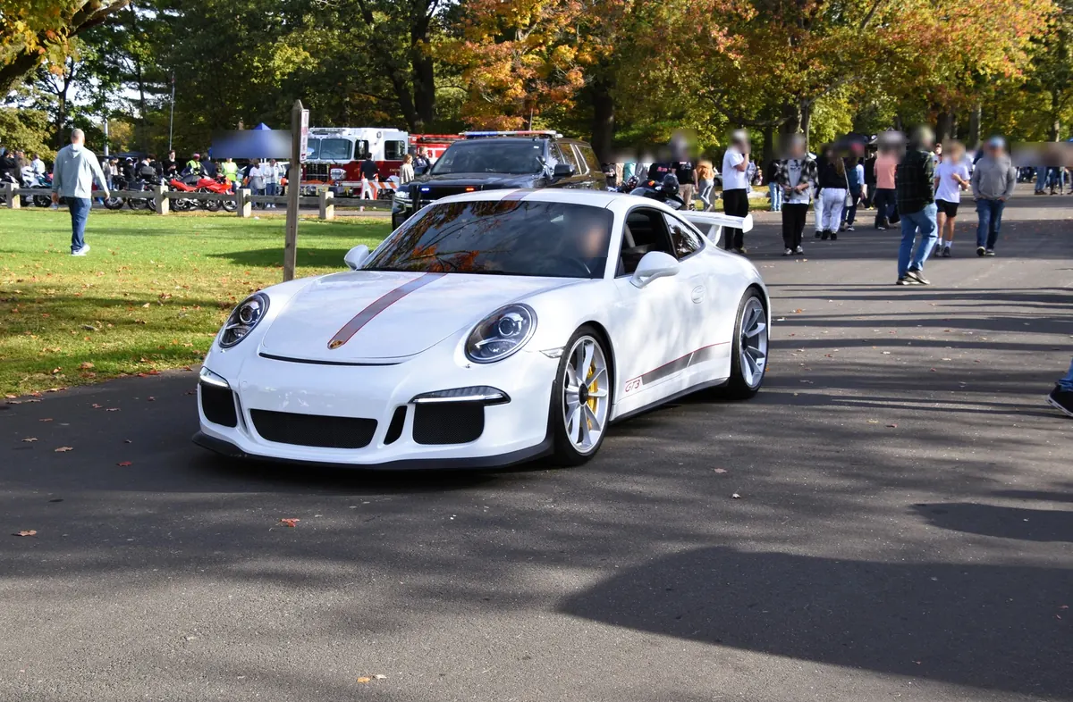 Front three-quarter view of a white Porsche 911 R (991.1) with red stripes at a car meet