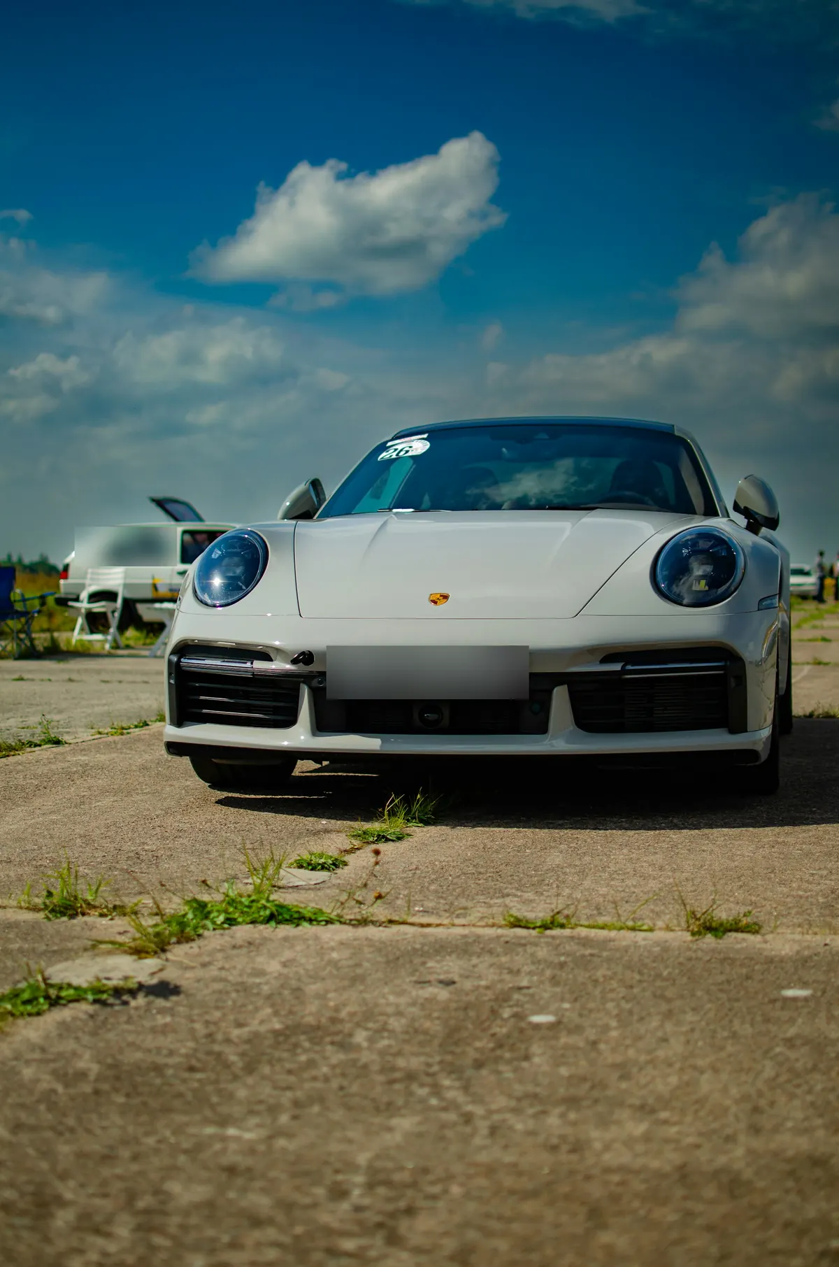 Front view of a light grey Porsche 911 Turbo (992.1) at a track day
