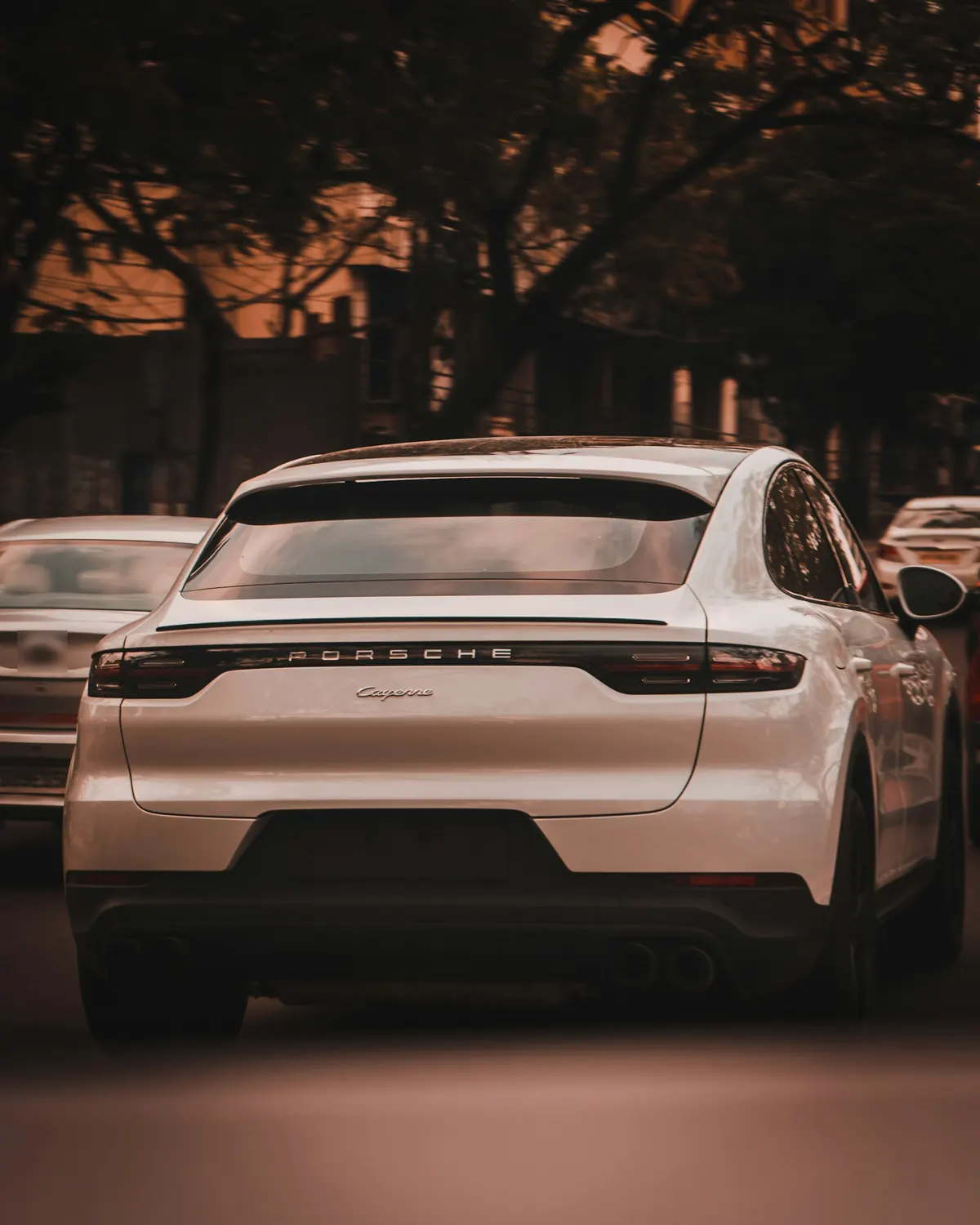 Rear view of a white Porsche Cayenne Coupe (E3.1) in city traffic