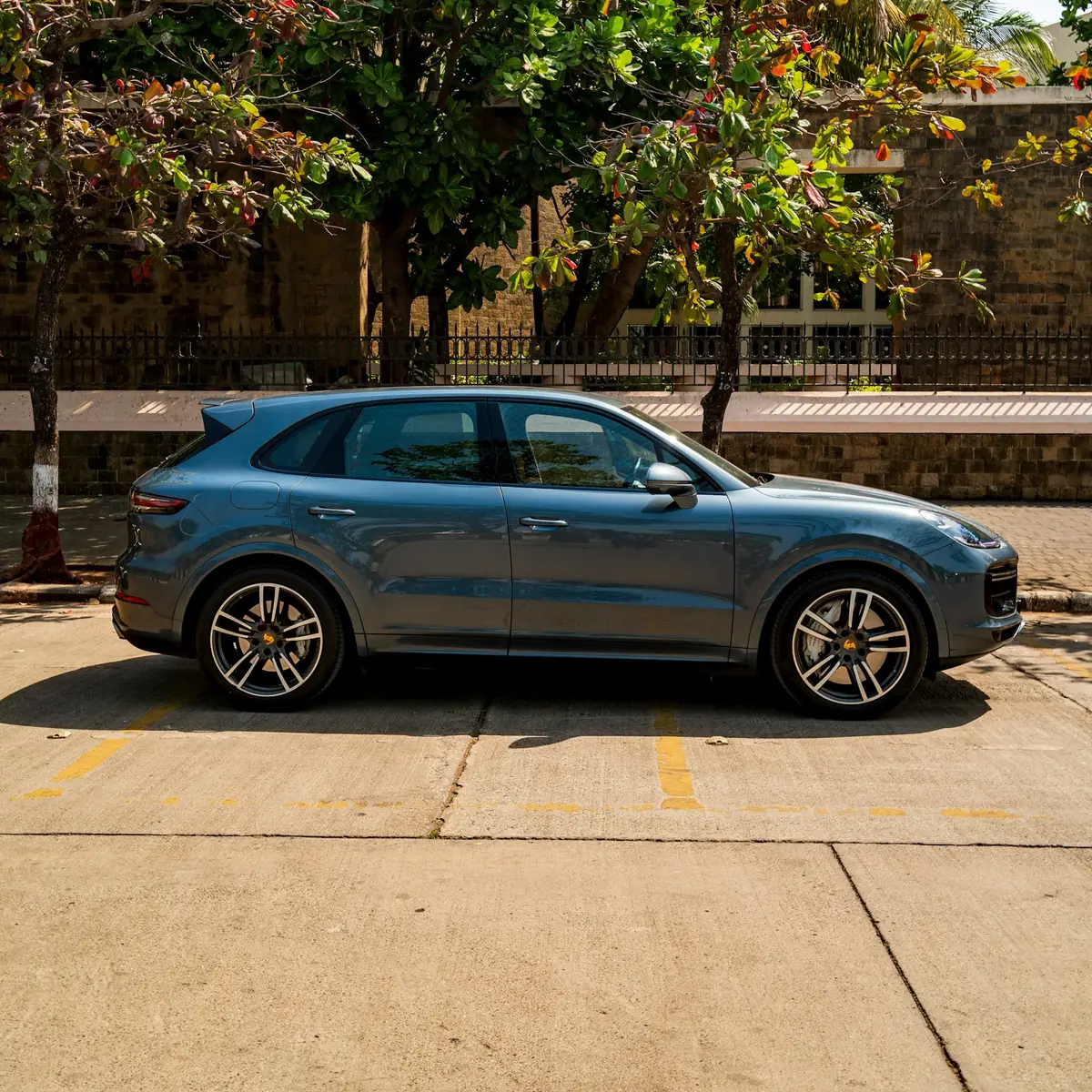 Side view of a blue Porsche Cayenne Turbo (E3.1) parked on a street