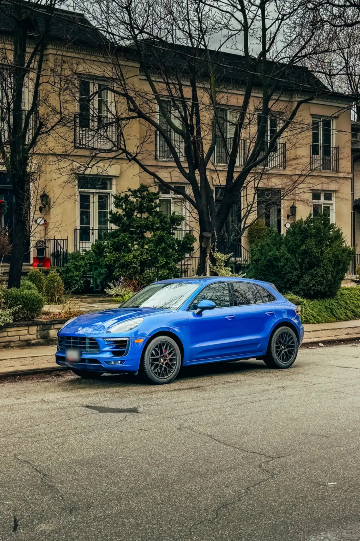 Front three-quarter view of a blue Porsche Macan GTS (95B.1) parked on a residential street