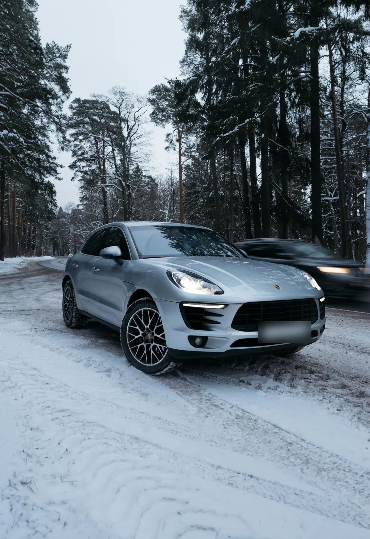 Front three-quarter view of a silver Porsche Macan S (95B.1) on a snowy forest road