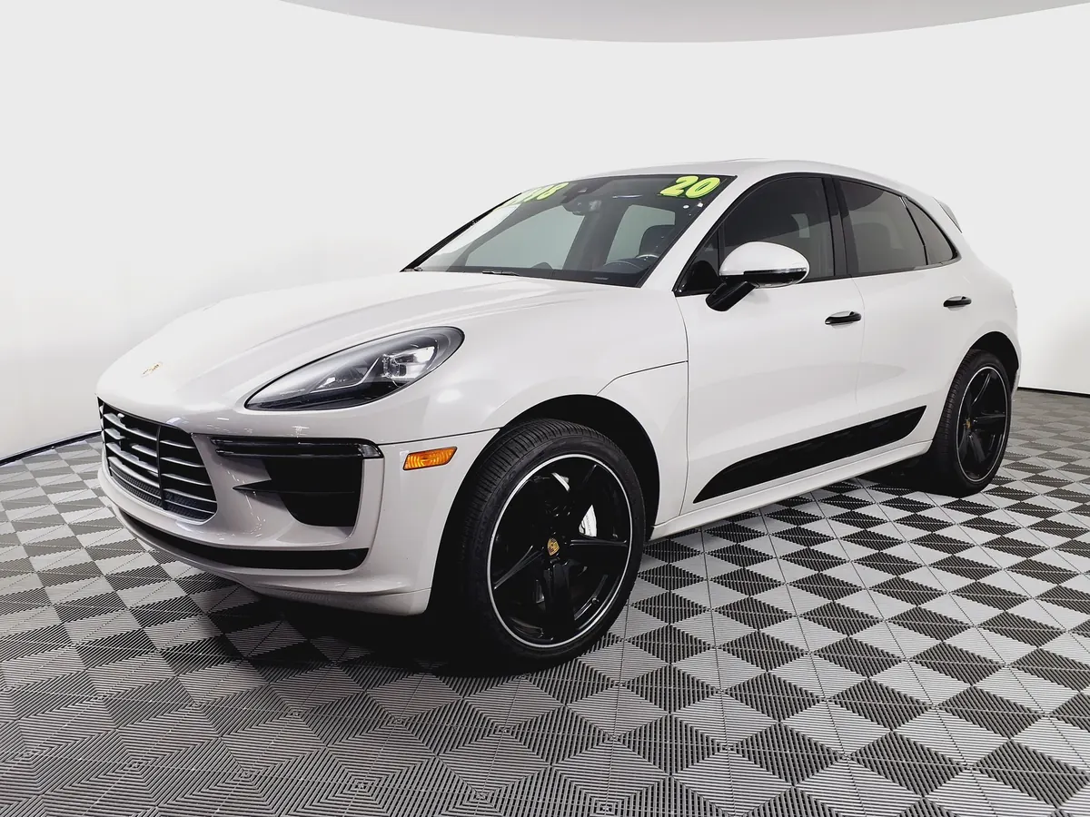 Front three-quarter view of a white Porsche Macan Turbo (95B.2) in a dealer photo bay