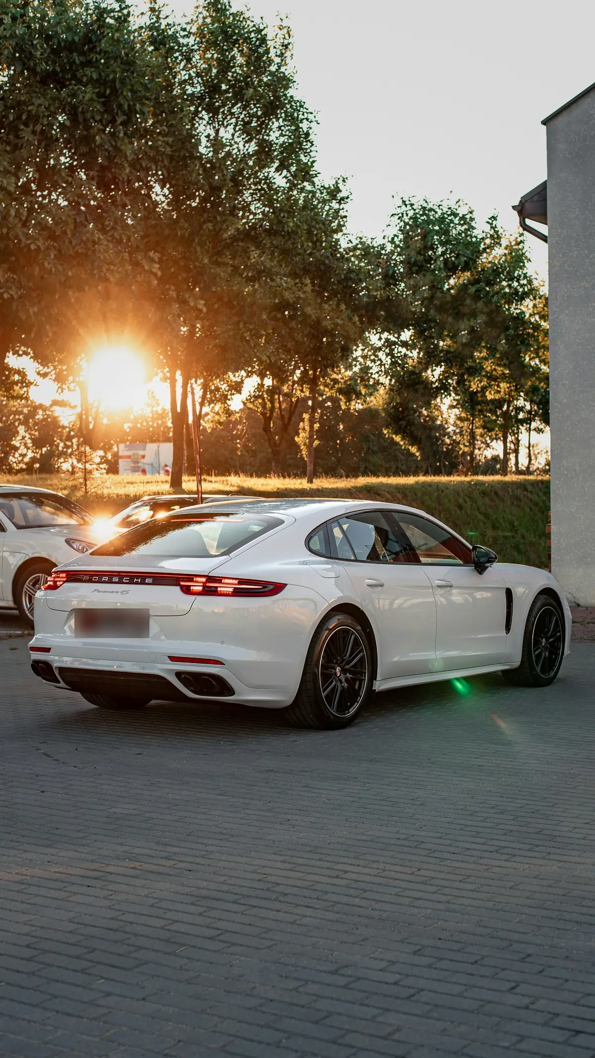 Rear three-quarter view of a white Porsche Panamera 4S (971.2) at sunset