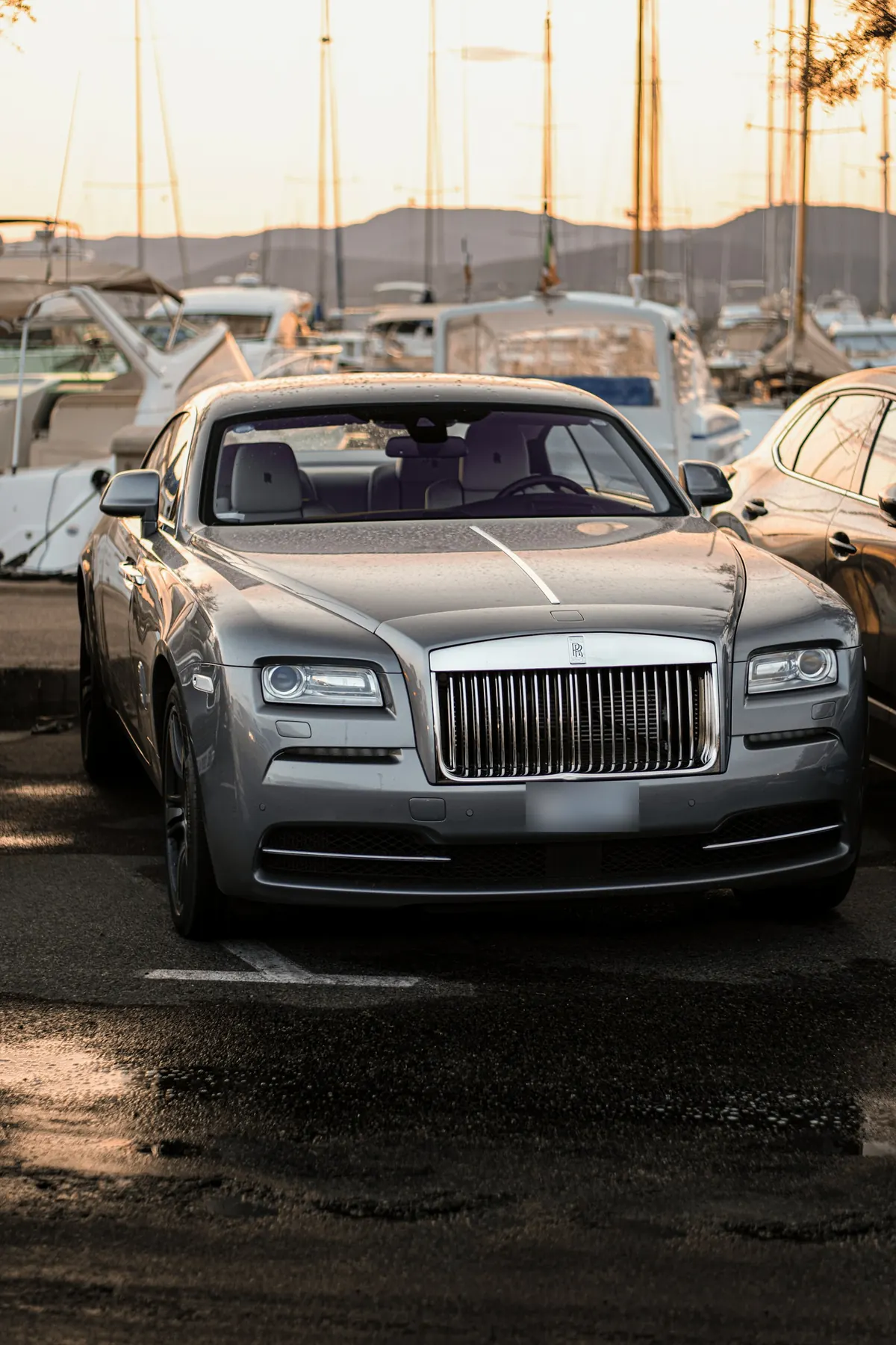 Front view of a silver Rolls-Royce Wraith parked at a marina