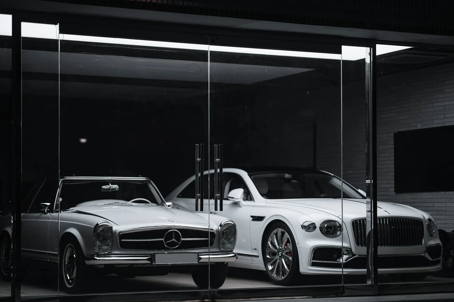 Classic Mercedes-Benz SL Pagoda and a Bentley Flying Spur in a showroom