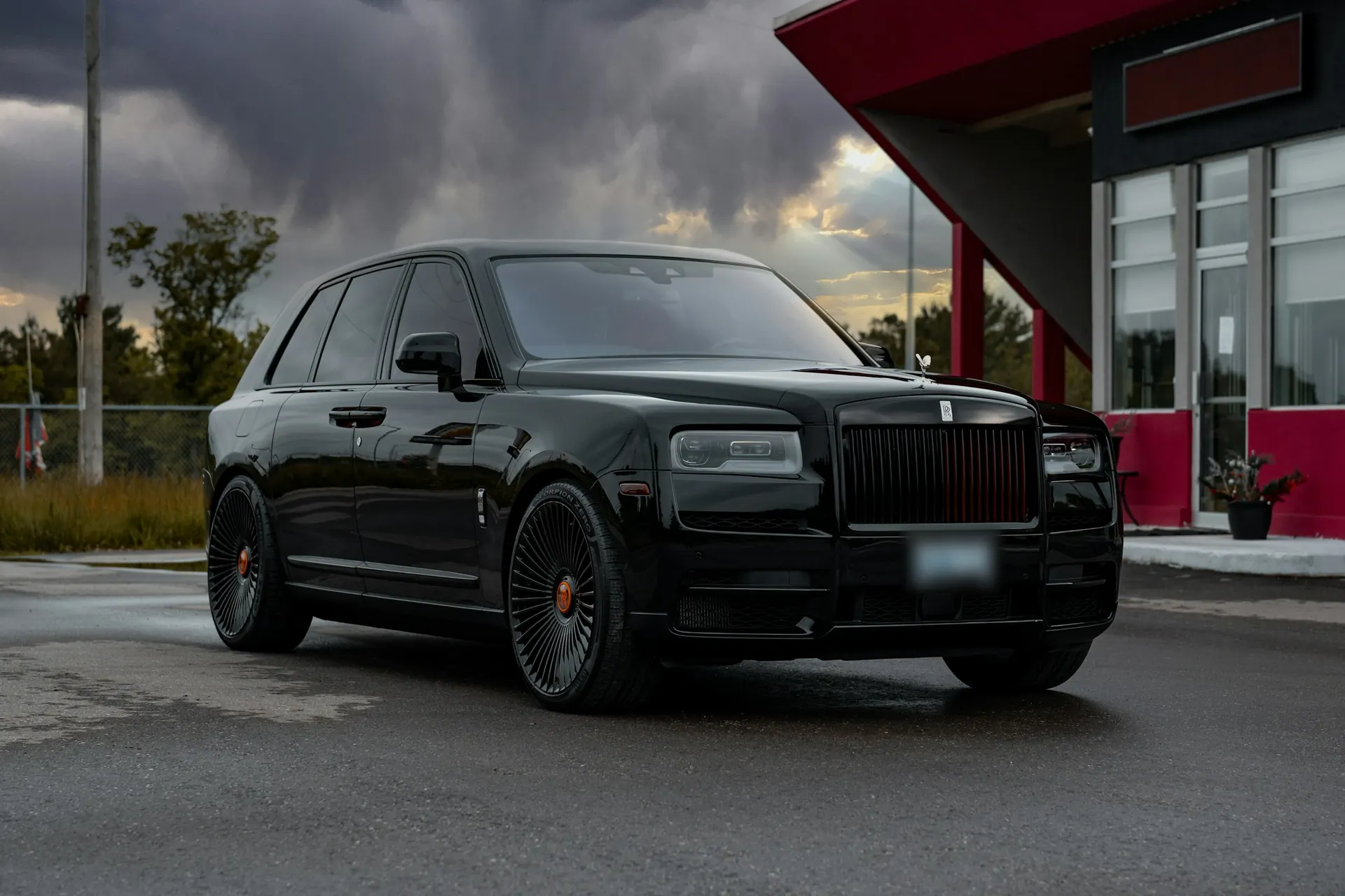 Black Rolls-Royce Cullinan under a stormy sky